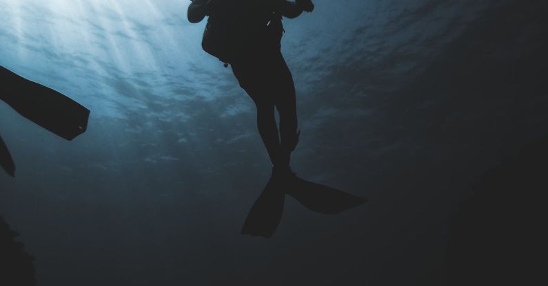 Swim Gear - Silhouette of scuba diver underwater