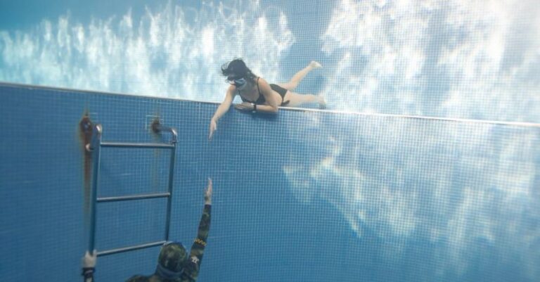 Swim Pull - Anonymous couple swimming underwater in pool near hole