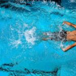 Swim Workouts - Person Swimming on Body of Water