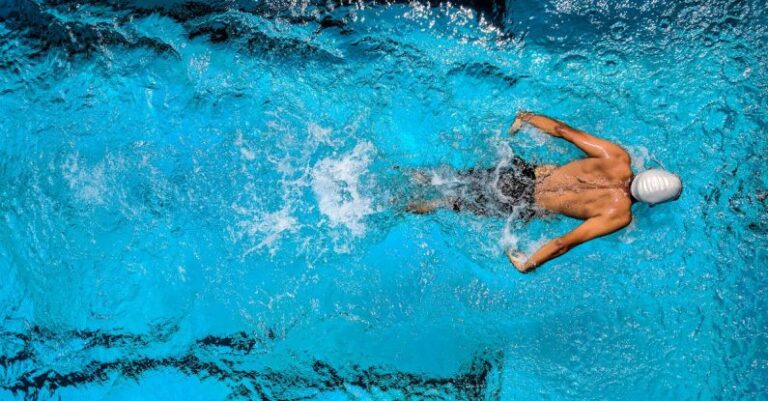 Swim Workouts - Person Swimming on Body of Water