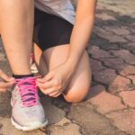 Running Shoes - Woman Lacing Up Her Gray and Pink Nike Low-top Athletic Shoe