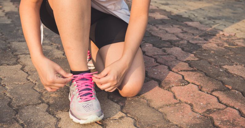 Running Shoes - Woman Lacing Up Her Gray and Pink Nike Low-top Athletic Shoe