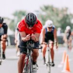 Triathlon Bike - Unrecognizable cyclists riding bikes on road during race