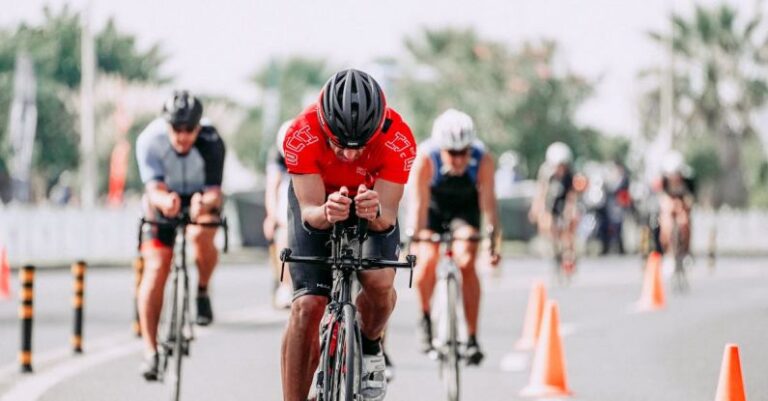 Triathlon Bike - Unrecognizable cyclists riding bikes on road during race