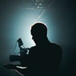 Triathlon Gear - Silhouette of Man Standing in Front of Microphone