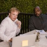 Training Gadgets - Men in Gray and White Sweater Sitting Near the Table while Looking at the Laptop