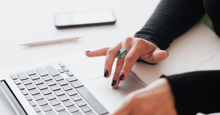 Pacing Strategy - Crop female using touchpad on laptop in office