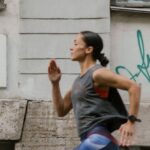 Speed Workouts - A Side View of a Woman Jogging on the Street