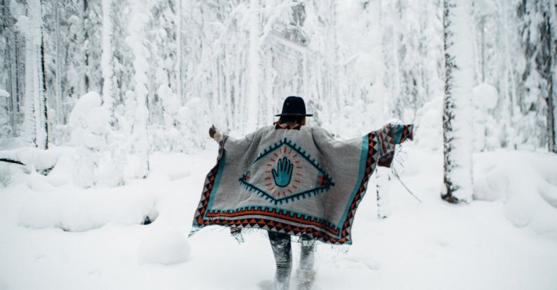 Running Injuries - Woman in poncho walking in winter forest