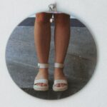 Proper Footwear - A round pendant with a picture of a woman's feet