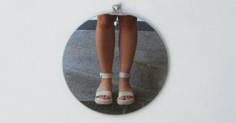 Proper Footwear - A round pendant with a picture of a woman's feet