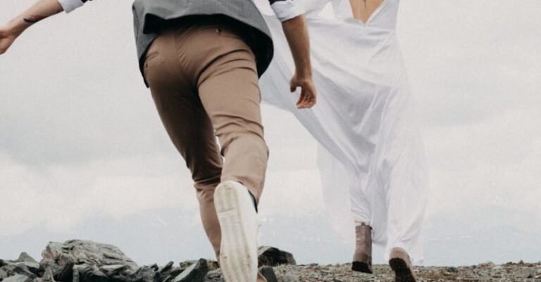 Running Terrains - Anonymous groom catching up bride on rocky land