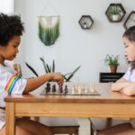 Training Plan - Multiethnic thoughtful girls playing chess in modern room