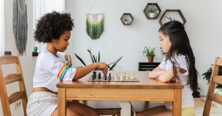 Training Plan - Multiethnic thoughtful girls playing chess in modern room